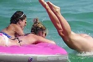 Топлесс дамы наслаждаются на пляже в то время как парни смотрят на их упругие сиськи