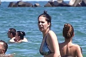 Обнаженные женщины на пляже в то время как озабоченный вуайерист делае...