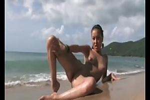 Одинокая Азиатская девушка показывает свое обнаженное мокрое тело с удовольствием в то время как на пляже