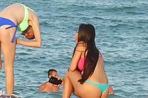 Adorable girls are having a great time on the beach while guys are checking out their asses